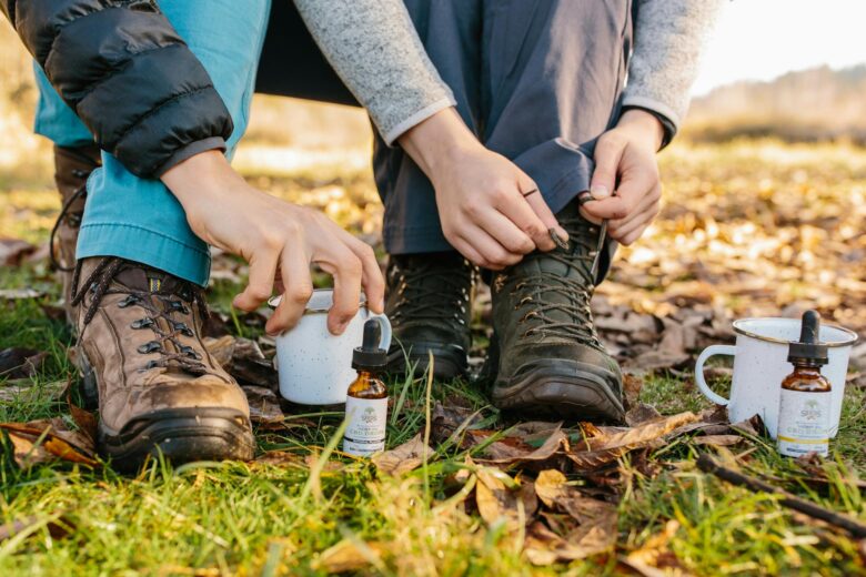 person fixing it s shoelace near cups and medicine bottles